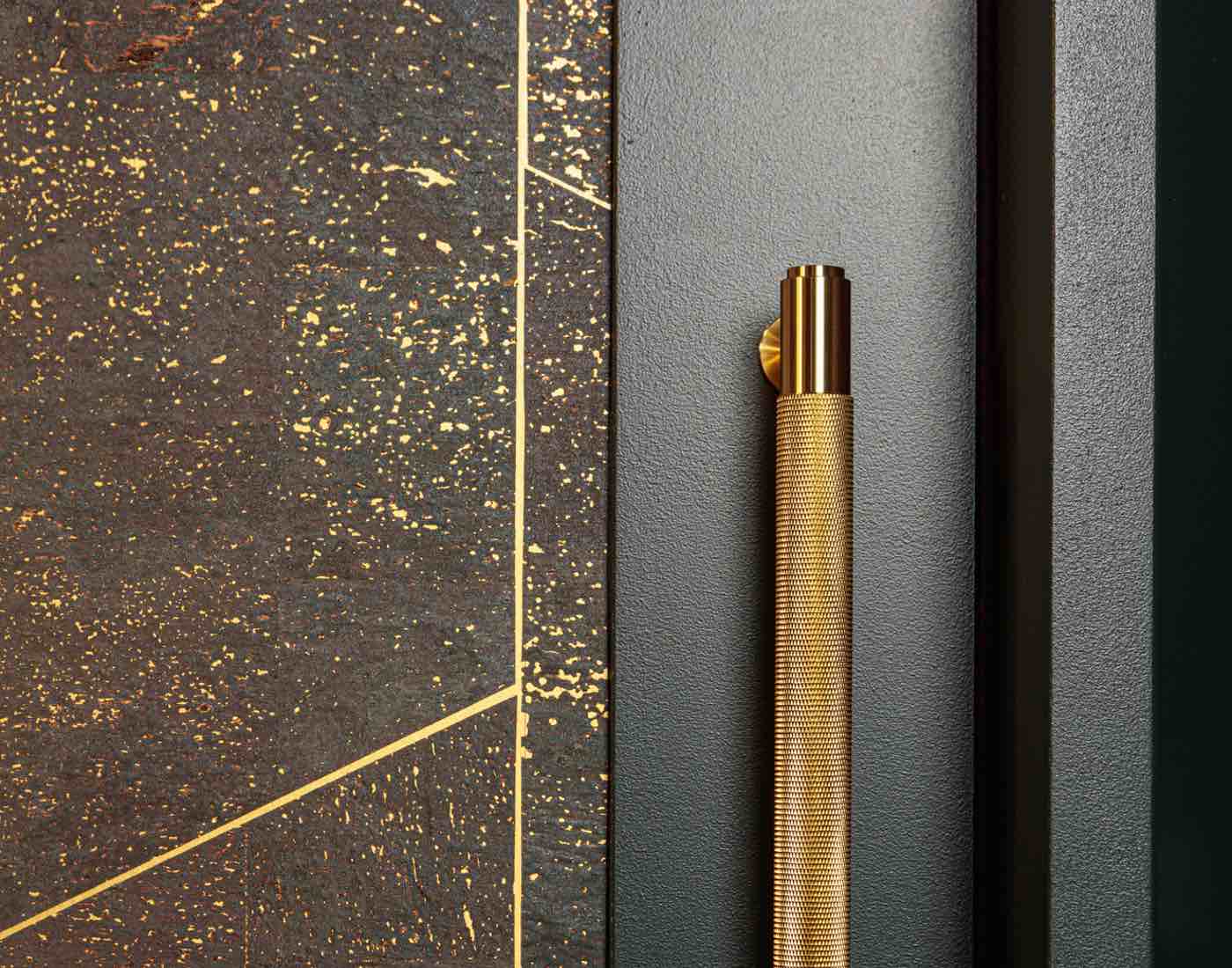 Close up of tiling with gold colour grout and brass fixtures