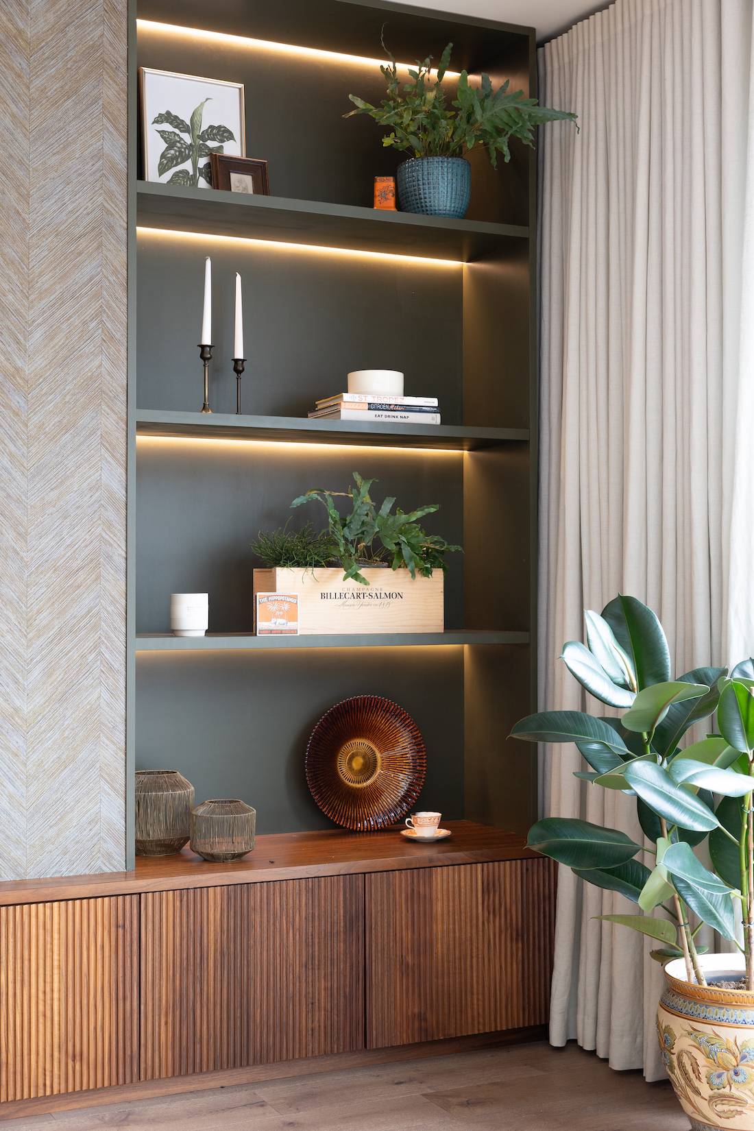 Contemporary Snug Shelving Designed with Bespoke Joinery by Pfeiffer Design. Warm wood joinery with dark green paint in recess and textured wallpaper with warm LED lighting design