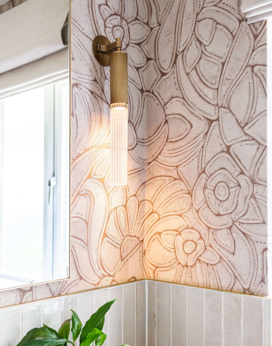 Art Deco Inspired Guest Bathroom/ Downstairs WC designed by Pfeiffer Design. Textured wallpaper in pale pink with half height tiling below, deep burgundy vanity unit with gold accent handles, warm wall lighting in a guest downstairs bathroom WC